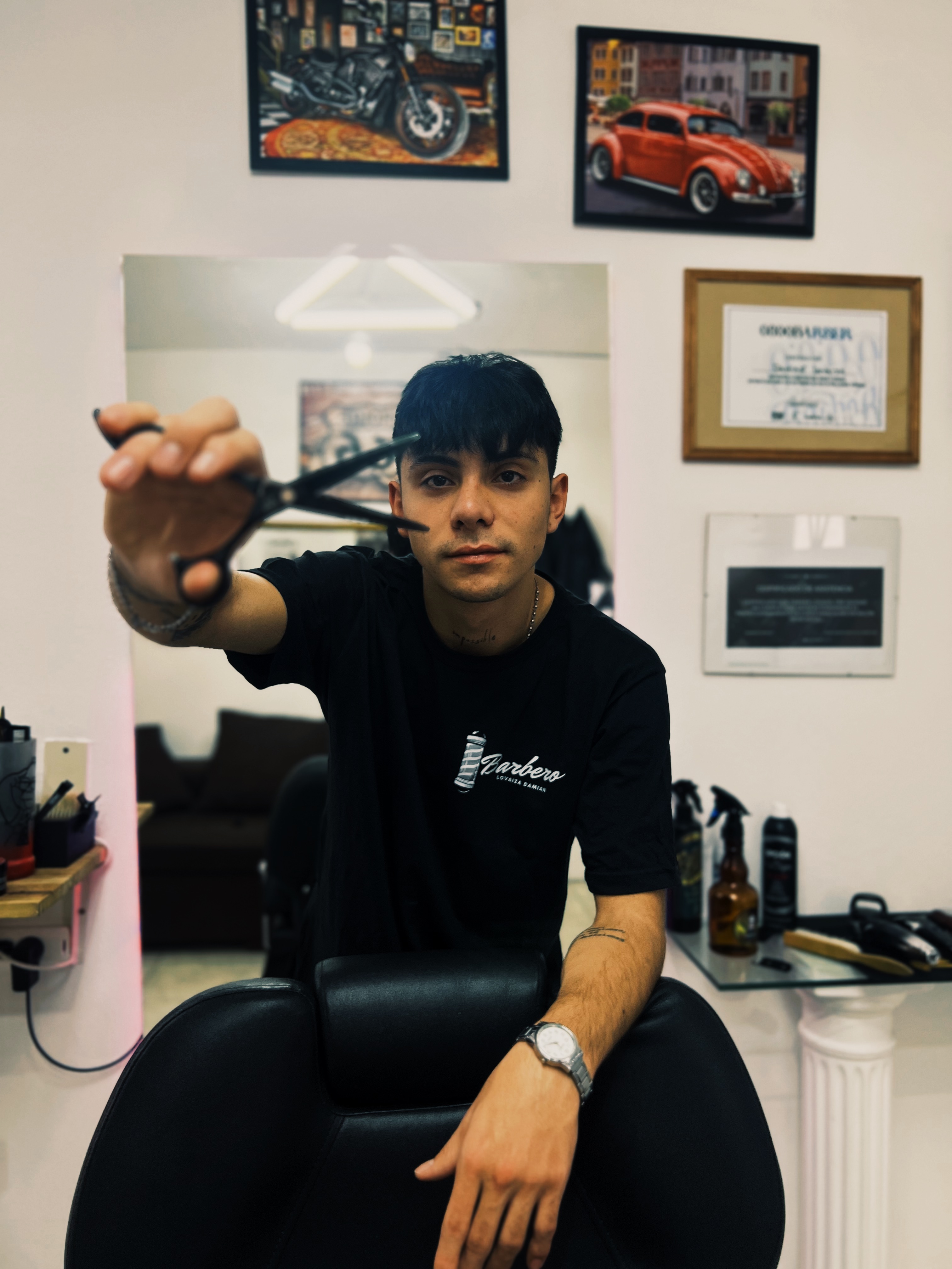 Damián Lovaiza, barbero, con tijera en mano en su local